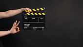hands is holding clapper board or clapperboard or movie slate.It is used in video production and film industry on black background