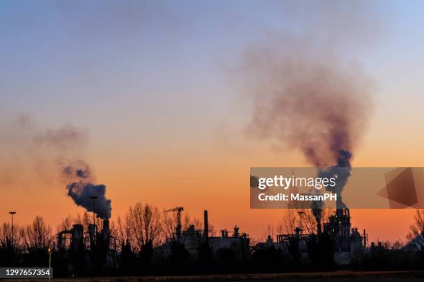 smoke from factory chimneys at sunset - factory smog stock pictures, royalty-free photos & images