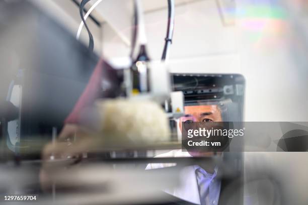 hombre de raza mixta madura observando impresora 3d en el trabajo - organe de reproduction masculin fotografías e imágenes de stock