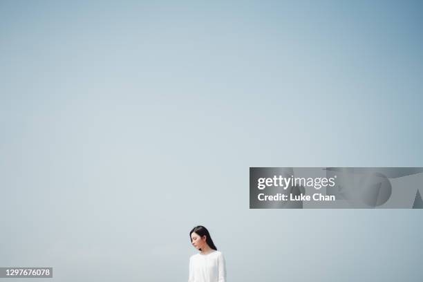 het jonge aziatische meisje bestaat zich kalm achter de grote blauwe hemel in een mooie zonnige dag - dream big stockfoto's en -beelden