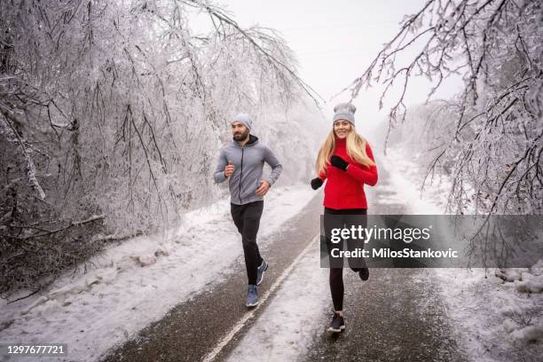 jogging on snowy winter day - jogging winter stock pictures, royalty-free photos & images