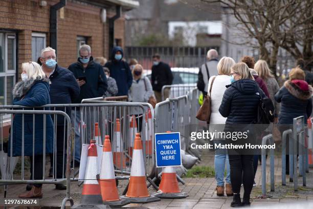 People queue for the Pfizer-BioNTech Covid-19 vaccine at Cardiff and Vale Therapy centre on Splott Road on January 21, 2021 in Cardiff, Wales. Wales...