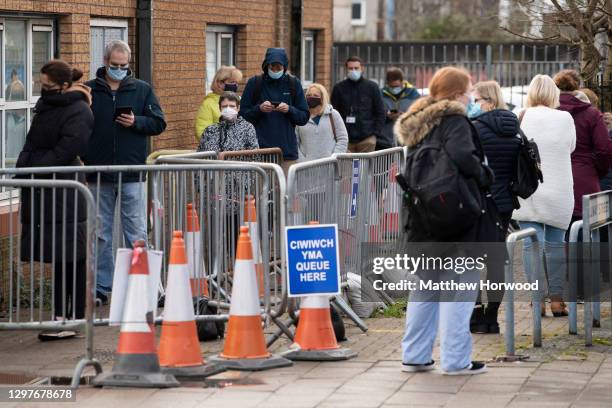 People queue for the Pfizer-BioNTech Covid-19 vaccine at Cardiff and Vale Therapy centre on Splott Road on January 21, 2021 in Cardiff, Wales. Wales...