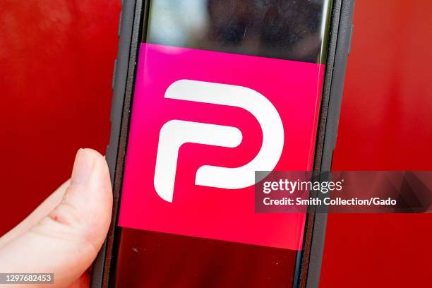 Illustrative image of human hand with mobile device showing logo for the social media platform Parler, Lafayette, California, January 21, 2021.