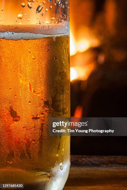 cold beer and fireplace - glasses condensation stock pictures, royalty-free photos & images