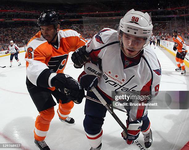 Andreas Lilja of the Philadelphia Flyers checks Marcus Johansson of the Washington Capitals along the boards at the Wells Fargo Center on October 20,...