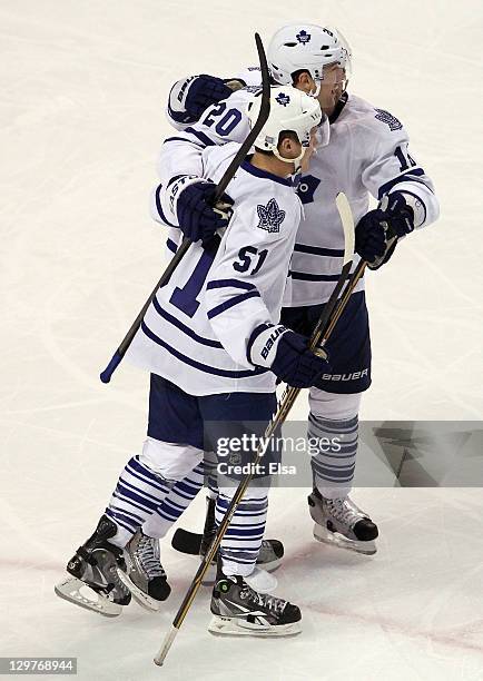 David Steckel of the Toronto Maple Leafs is congratulated by teammates Mike Brown and Jake Gardiner after Steckel scored in the first period against...