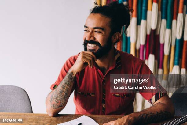 man sitting at table laughing - hipster persona stock-fotos und bilder