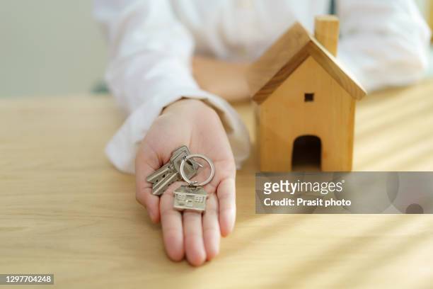 real estate house agent holding house key in hand. mortgage loan approval home loan and insurance concept. - agent and handing keys stock-fotos und bilder