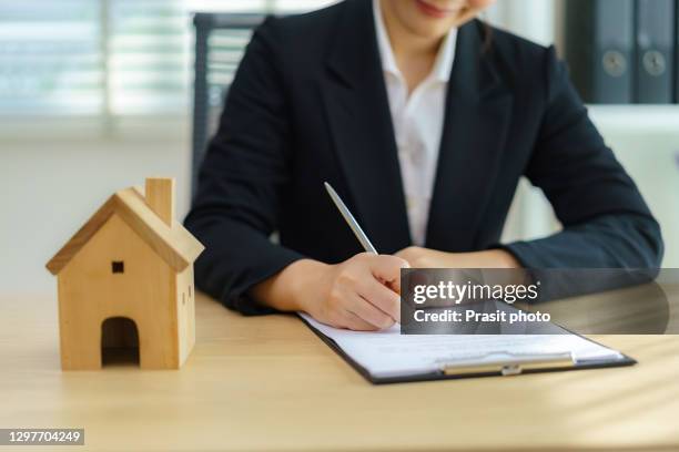 businesswoman are signing a house purchase contract, the concept of selling a home is signing a contract. - real estate sign fotografías e imágenes de stock