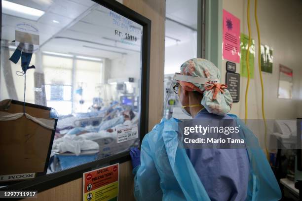 Certified registered nurse anesthetist Lisa Taft, who normally works in operating rooms, enters a room to care for COVID-19 patients in a makeshift...