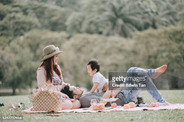 asiatische chinesische junge familie genießen picknick zeit im freien am wochenende - asien stock-fotos und bilder