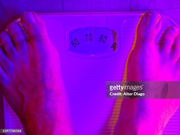 man measuring his weight on a scale. - bulimia nervosa - fotografias e filmes do acervo