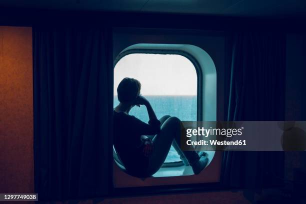 woman looking at view while sitting at ship window - mediterranean sea bildbanksfoton och bilder