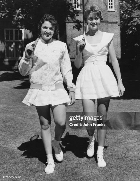 Renee Schuurman and Sandra Reynolds of South Africa pose for a photograph wearing new tennis outfits by fashion designer Teddy Tinling during Lady...