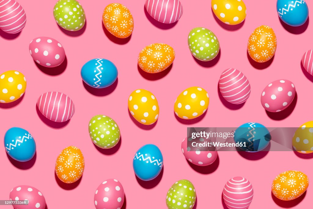 Handmade decorated Easter eggs on pink background