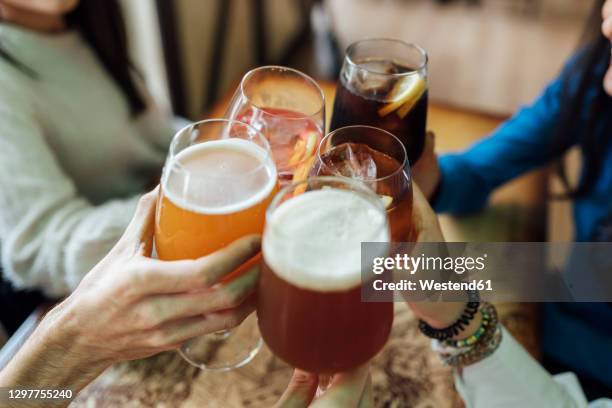 friends hands toasting wineglasses over table at bar - girls drinking beer stock pictures, royalty-free photos & images