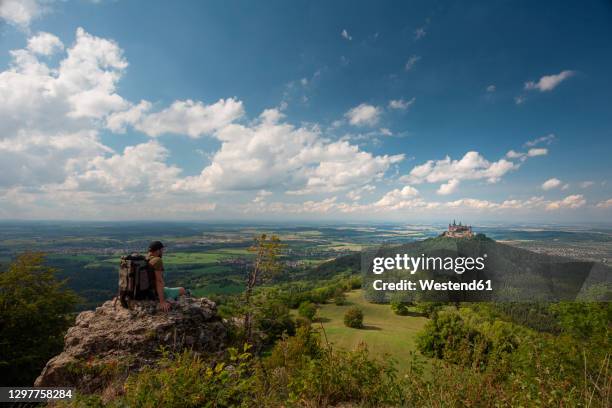 hiker looking at burg hohenzollern while sitting on mountain at swabian alb, germany - germany castle stock pictures, royalty-free photos & images