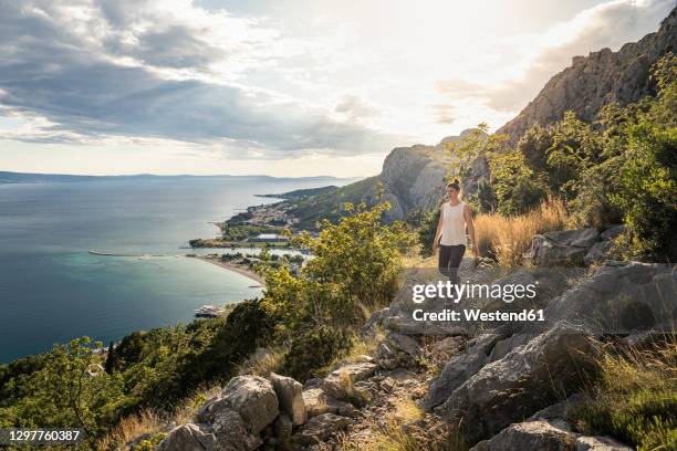 woman hiking on sea coast - croatia stock-fotos und bilder