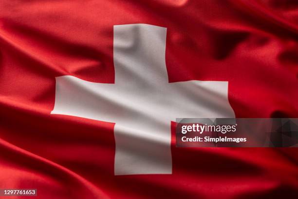 flag of switzerland blowing in the wind. - schweizer flagge stock-fotos und bilder