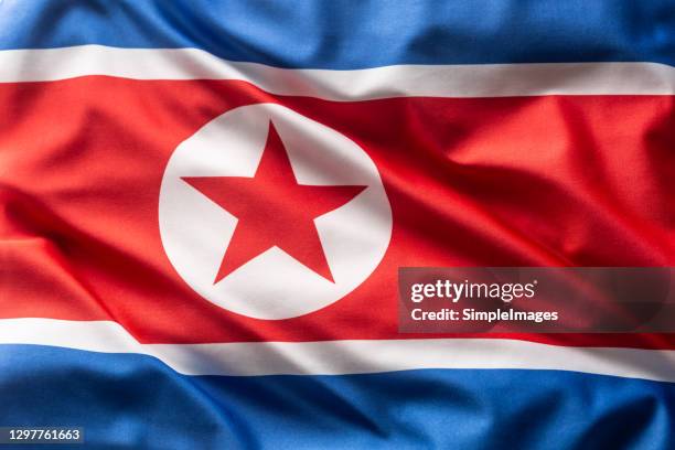 flag of north korea blowing in the wind. - norte fotografías e imágenes de stock