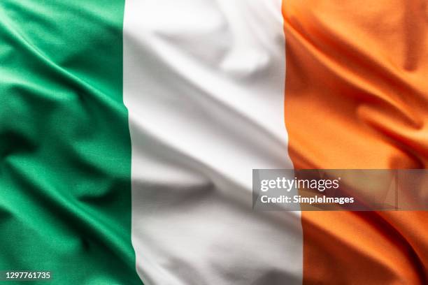 flag of irleand blowing in the wind. - irish flag abstract stock pictures, royalty-free photos & images