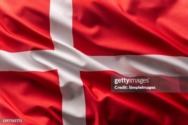 flag of denmark blowing in the wind. - danish flag stock-fotos und bilder