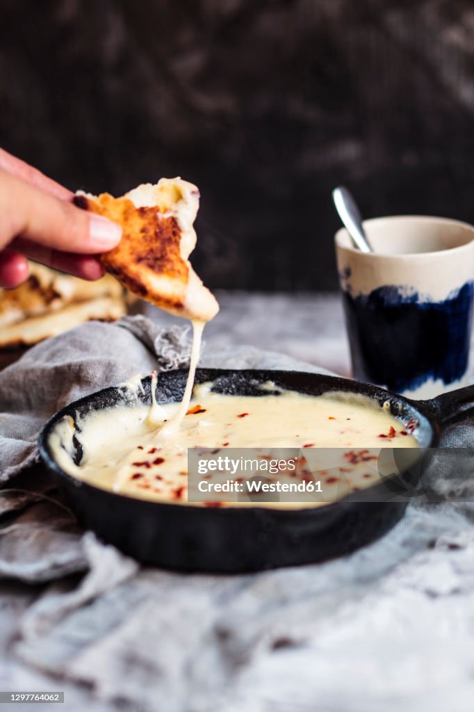 Woman having Kuymak from cooking pan on table