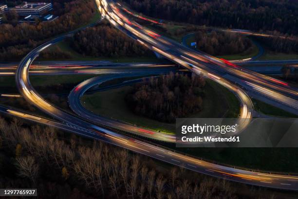 germany, baden-wurttemberg, stuttgart, aerial view of vehicle light trails on bundesautobahn 8 at dusk - straßenüberführung stock-fotos und bilder