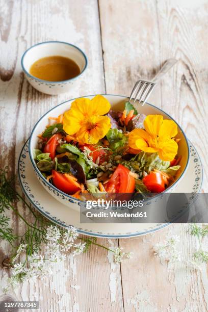bowl of vegetarian salad with edible flowers - kapuzinerkresse stock-fotos und bilder