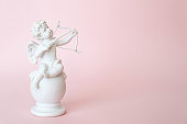 figurine of an angel Cupid with a bow on a pink background. Valentine's Day