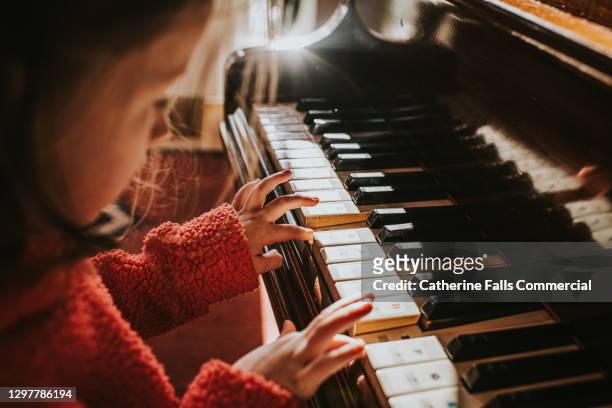 top down image of a little girl playing a grand piano - pianist imagens e fotografias de stock