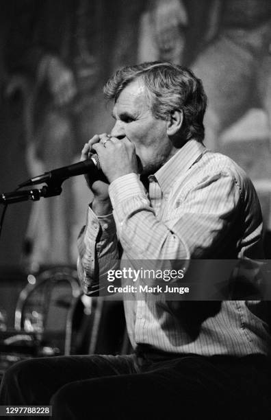 North Carolinian guitarist and folksinger Doc Watson plays his harmonica at the Sundance Saloon on October 13, 1985 in Fort Collins, Colorado. Arthel...