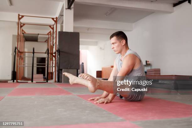 gymnaste mâle pratiquant l’exercice d’équilibre - jambes écartées photos et images de collection