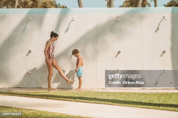 mother and son taking a shower outdoors - bath shower stock pictures, royalty-free photos & images