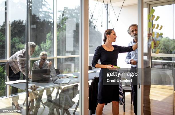 empresarios que trabajan en la oficina - director ejecutivo fotografías e imágenes de stock
