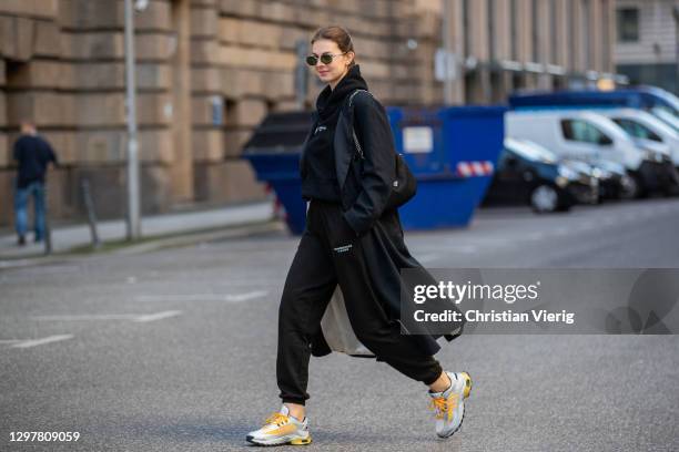 Jacqueline Zelwis is seen wearing black trench coat Barena Venezia, Onweekends jogger and hoody, Adidas sneaker, Prada bag, Persol sunglasses on...