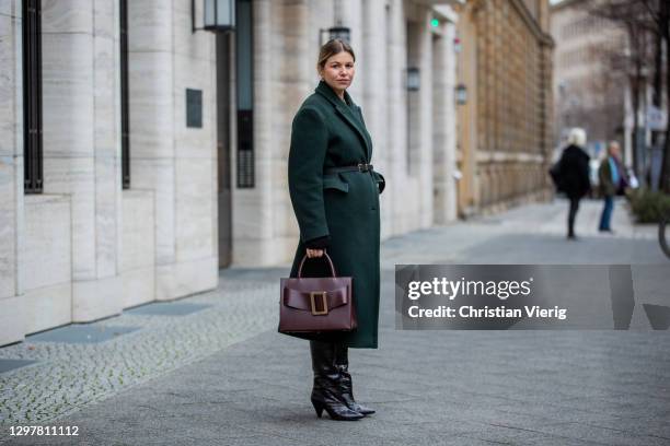 Aline Kaplan is seen wearing green coat Arket, burgundy bag Boyy Boutique, black boots Samsoe Samsoe on January 22, 2021 in Berlin, Germany.