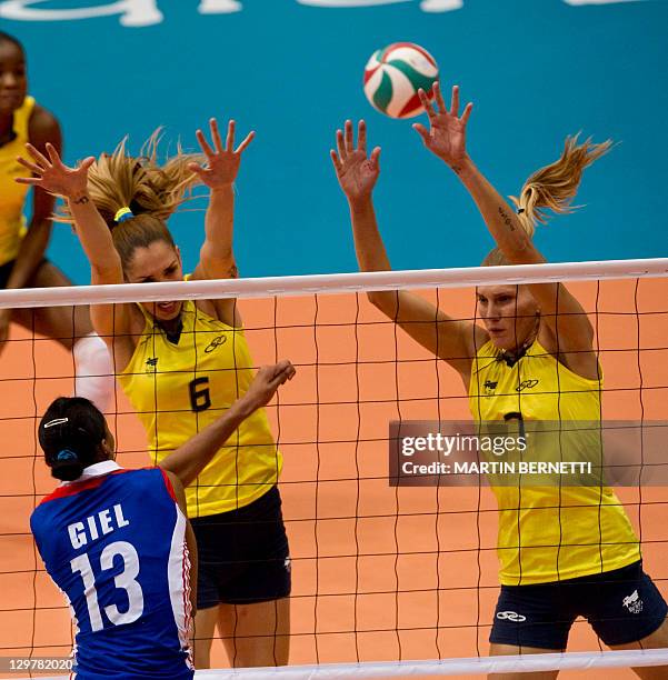 Thaisa Meneses and Marianne Steinsbrecher from Brazil block the ball against Cuba's Rosanna Giel during their final volleyball match at the Pan...