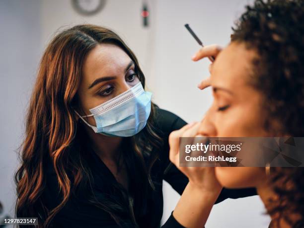 makeup artist at work in a studio - diverse film set stock pictures, royalty-free photos & images