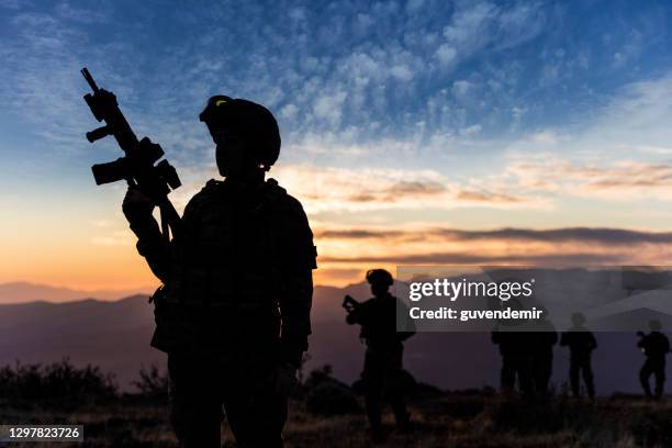 soldat féminin restant au coucher du soleil pendant une mission militaire - anti-terrorisme photos et images de collection