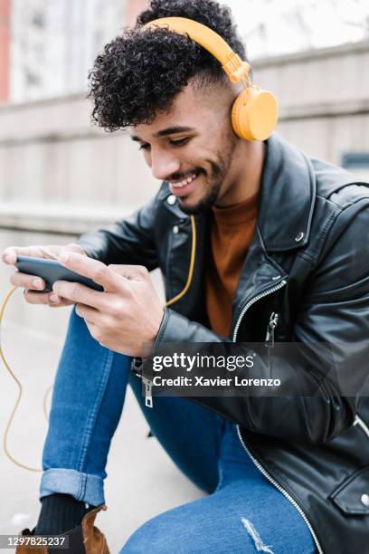 afro man playing video games on his smartphone - player video stock pictures, royalty-free photos & images