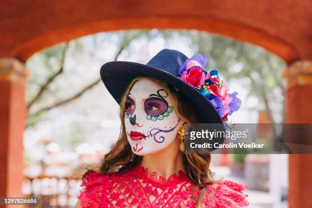 portrait of young woman with face painted as calavera catrina for the dia de los muertos celebration in mexico - catrina mexico fotografías e imágenes de stock