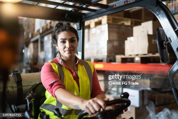 porträtt av en ung kvinna som kör en gaffeltruck i ett lager - manufacturing occupation bildbanksfoton och bilder