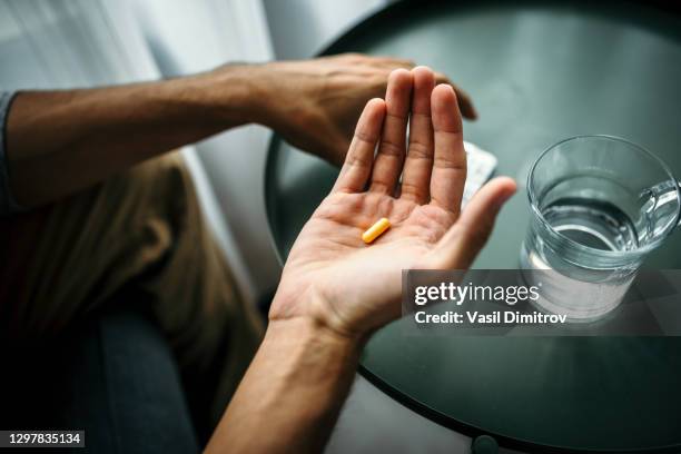 onherkenbare mens die een pil voor een lijst met glas water houdt. medische behandeling / drugsgebruik concept. - antidepressants stockfoto's en -beelden