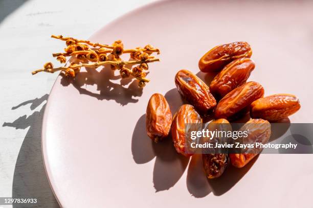 some date fruits on a pink plate - date fruit fotografías e imágenes de stock