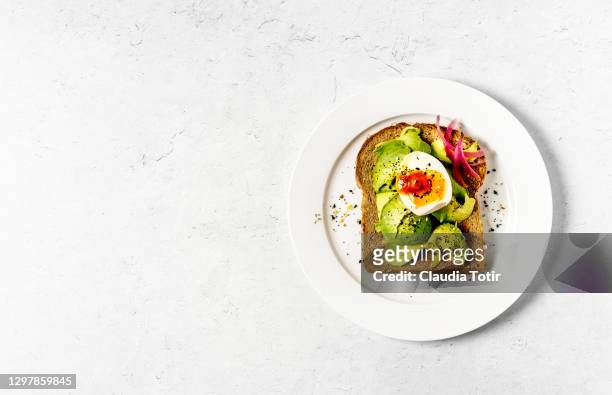 toast with boiled eggs and avocado on white background - hard boiled eggs stock-fotos und bilder