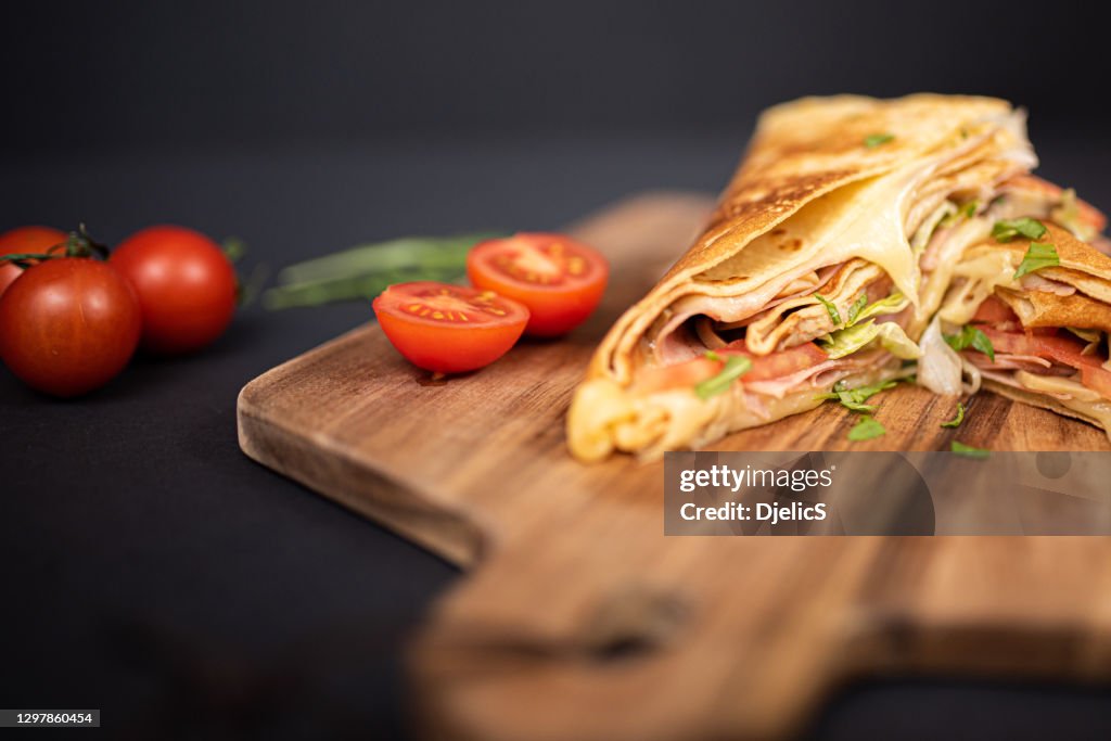 Crepes, dünne Pfannkuchen mit Schinken, Käse, Pilzen und Tomaten.