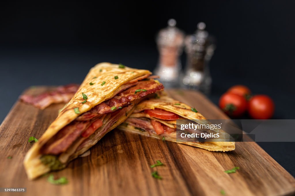 Crepes, dünne Pfannkuchen mit Speck, Käse, Eisbergsalat und Tomaten.