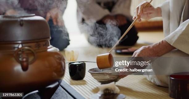 anfitriona ladling agua en bowl en la ceremonia del té - wabi sabi fotografías e imágenes de stock